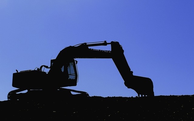 Digger silhouetted against a blue evening sky, crystal ball construction