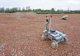 An ESA team member operates the rover on one of the team's tests sites.