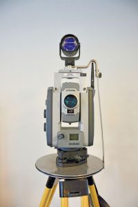 A total station and top-mounted prism as- sembly for reciprocal measurements. The prism rides in a rotatable bearing to provide stable orien- tation while the total station turns beneath it.