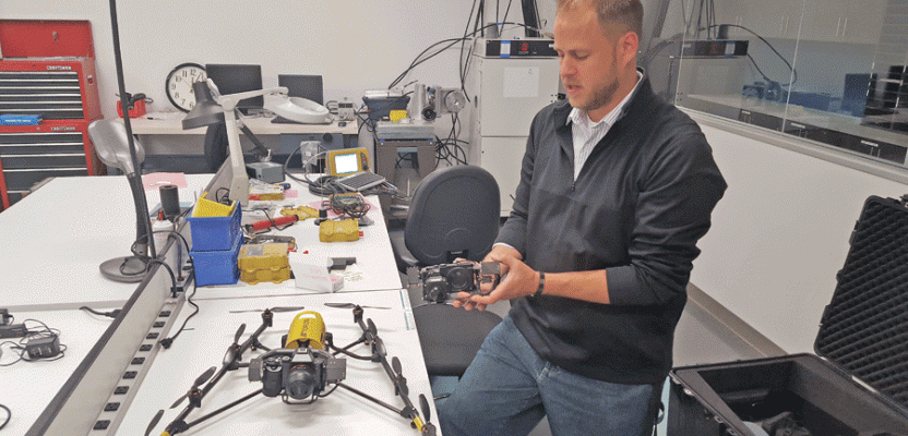 Applications engineer Jeff DeBoer demonstrates interchangeable payload options enabled by the “V” airframe of the new UAS, Falcon 8. Two models are offered: GeoEXPERT for surveying and InspectionPRO for industrial inspection.