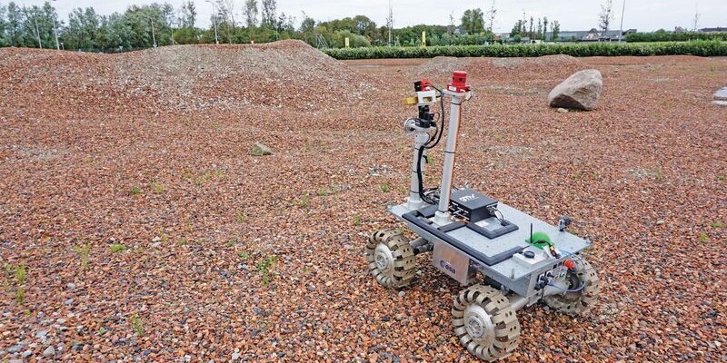 An ESA team member operates the rover on one of the team's tests sites.