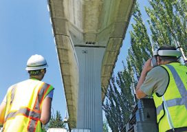 DEA’s remote pilot Ryan Reedy (left) and structural en- gineer/remote pilot Eric Ferluga (right) perform a structural inspection of a railway elevated guideway using HD video goggles. Not pictured is author Matt Kumpula who is ensuring that the flight is safe.