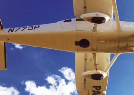 Looking up into the belly of a Cessna 206 airplane. The aerial photography camera is looking down through the hole.