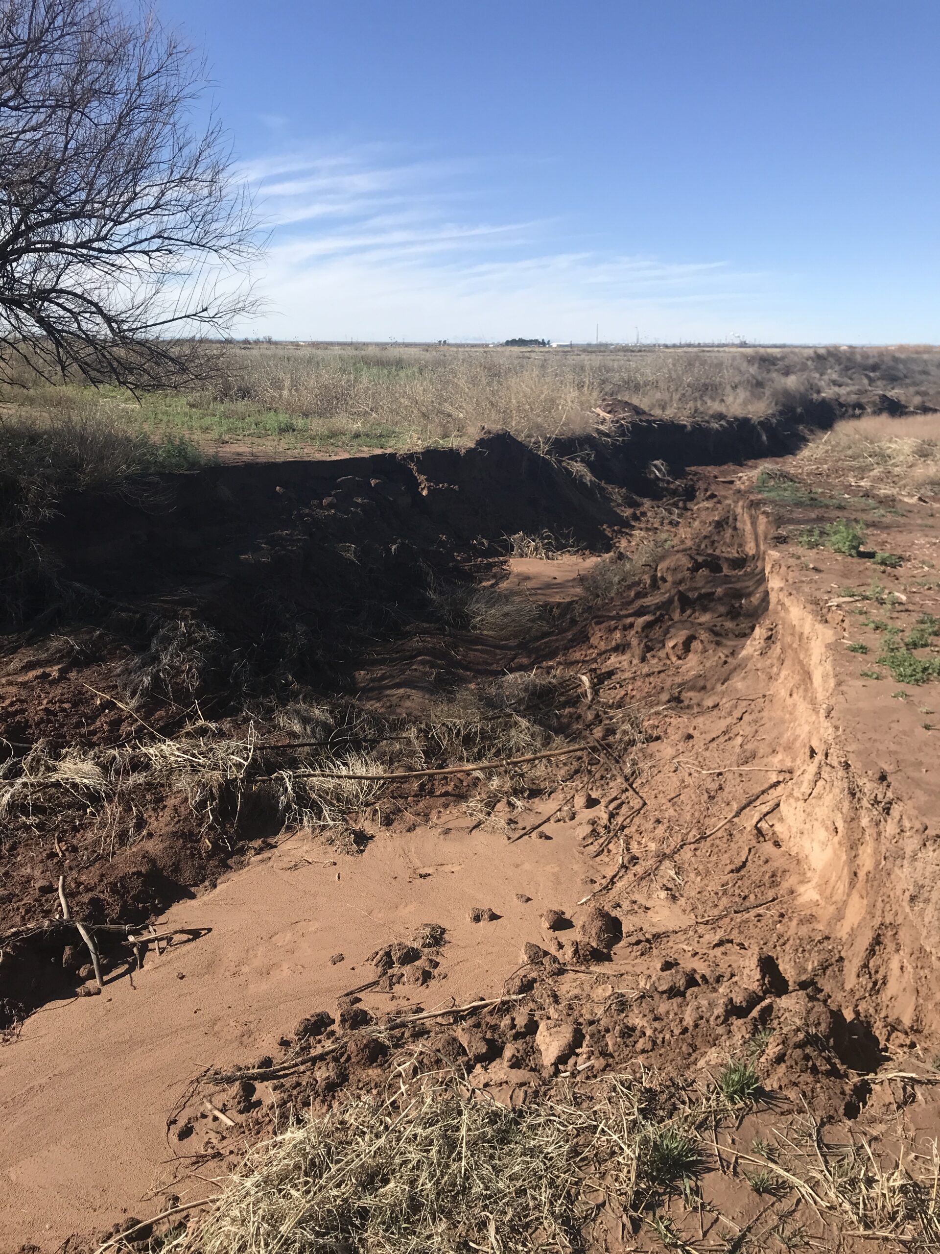 In 2019, Pecos River floodwater poured into an old riverbed, bypassing the designed spillway back to the river and creating a huge washout area.