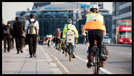 City workers walking and cycling over Waterloo Bridge at the end of the working day. Crash zoom effect done in camera.