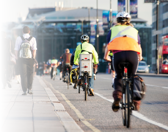 City workers walking and cycling over Waterloo Bridge at the end of the working day. Crash zoom effect done in camera.